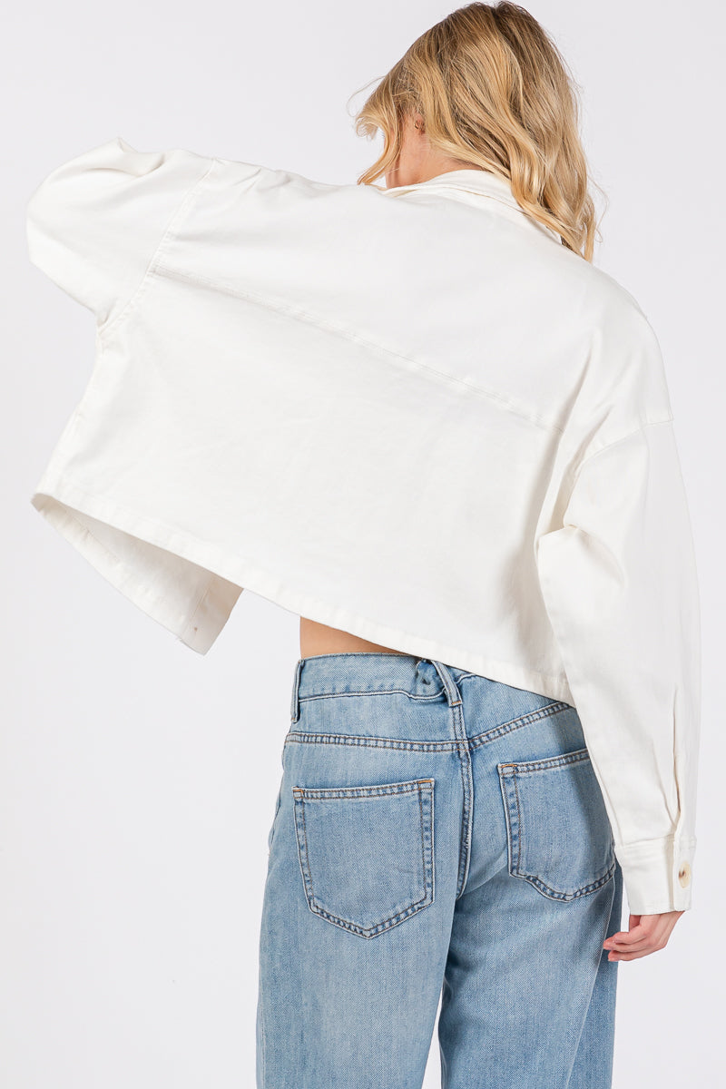 cropped white denim-style jacket with button-down front, worn over blue jeans, showcasing casual chic style.